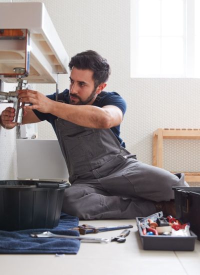 male-plumber-working-to-fix-leaking-sink-in-home-.jpg